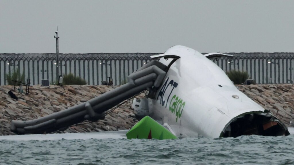 Two dead after plane slides off runway and crashes into car before plunging into sea at Hong Kong airport